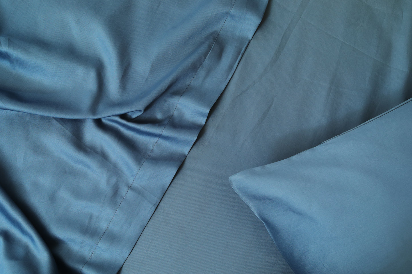 Soft midnight blue bed sheets set fabric folds close-up