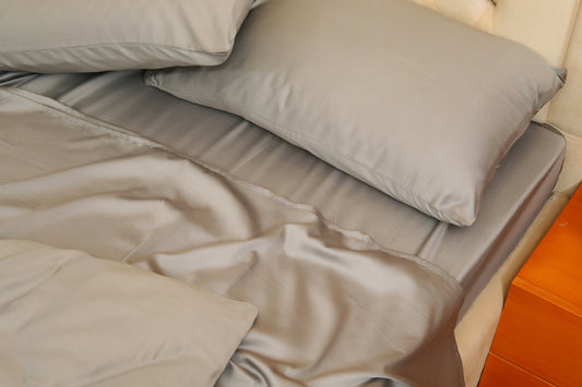Dark grey bed sheets set with pillow covers on a neatly made bed