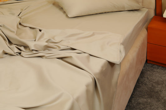 Greige cream fitted sheet with matching pillow on beige bed