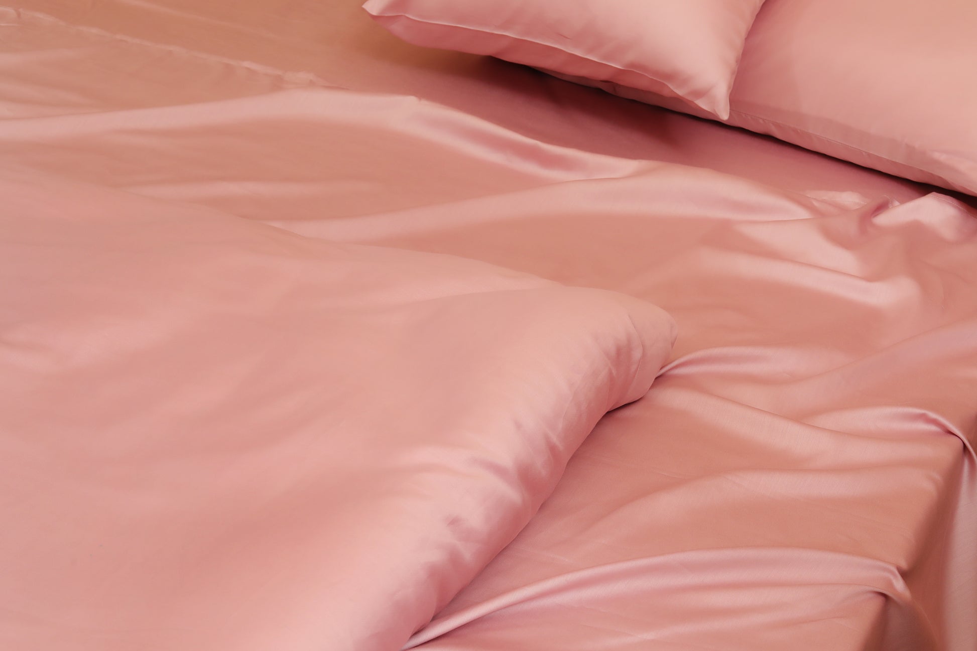 Close-up of pink quilt cover set fabric and smooth texture on bed corner